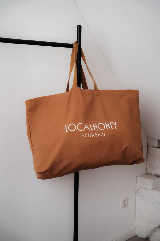 Stimmungsvolle Fotografie von Merch Artikeln – Localhoney Schwerin im Fokus.